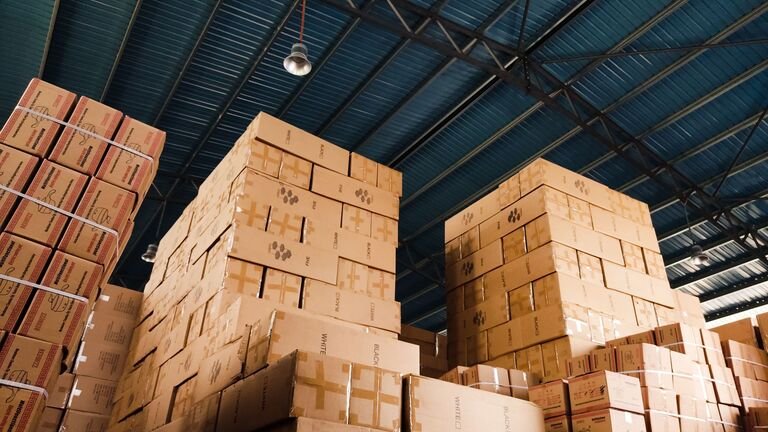 Cajas de cartón apiladas hasta el techo en la nave de un almacén de custodia